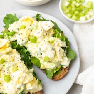 Salade aux œufs à faible teneur en sodium servie sur deux tranches de pain grillé avec de la laitue sur une assiette blanche