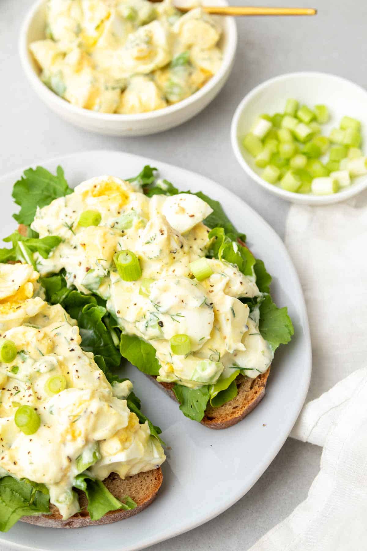 Salade aux œufs à faible teneur en sodium servie sur deux tranches de pain grillé avec de la laitue sur une assiette blanche