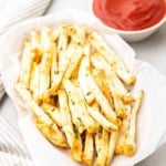 Gros plan de frites de céleri-rave dans un panier à côté d'un ramequin de ketchup