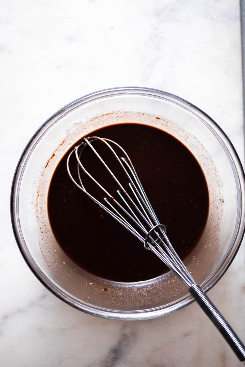 Ganache soyeuse au chocolat dans un bol avec un fouet