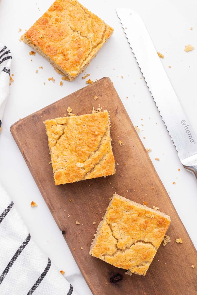 3 carrés de pain de maïs à faible teneur en glucides sur une planche à découper en bois