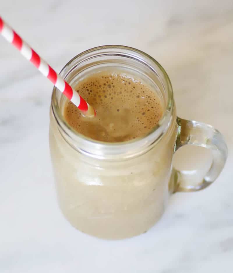 Verre de smoothie protéiné au beurre d'arachide végétalien avec une paille