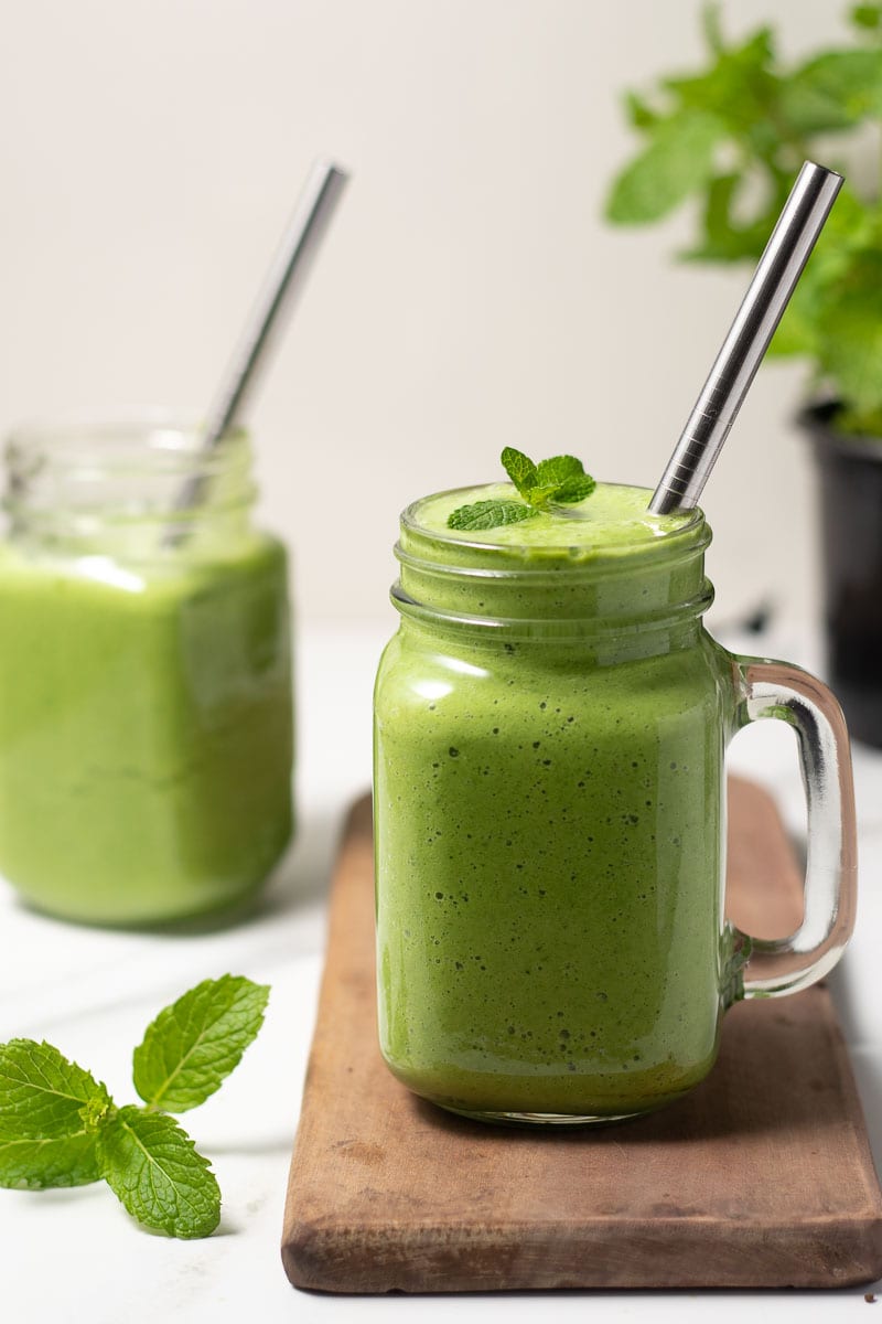 Smoothie vert servi dans un verre avec une paille en métal